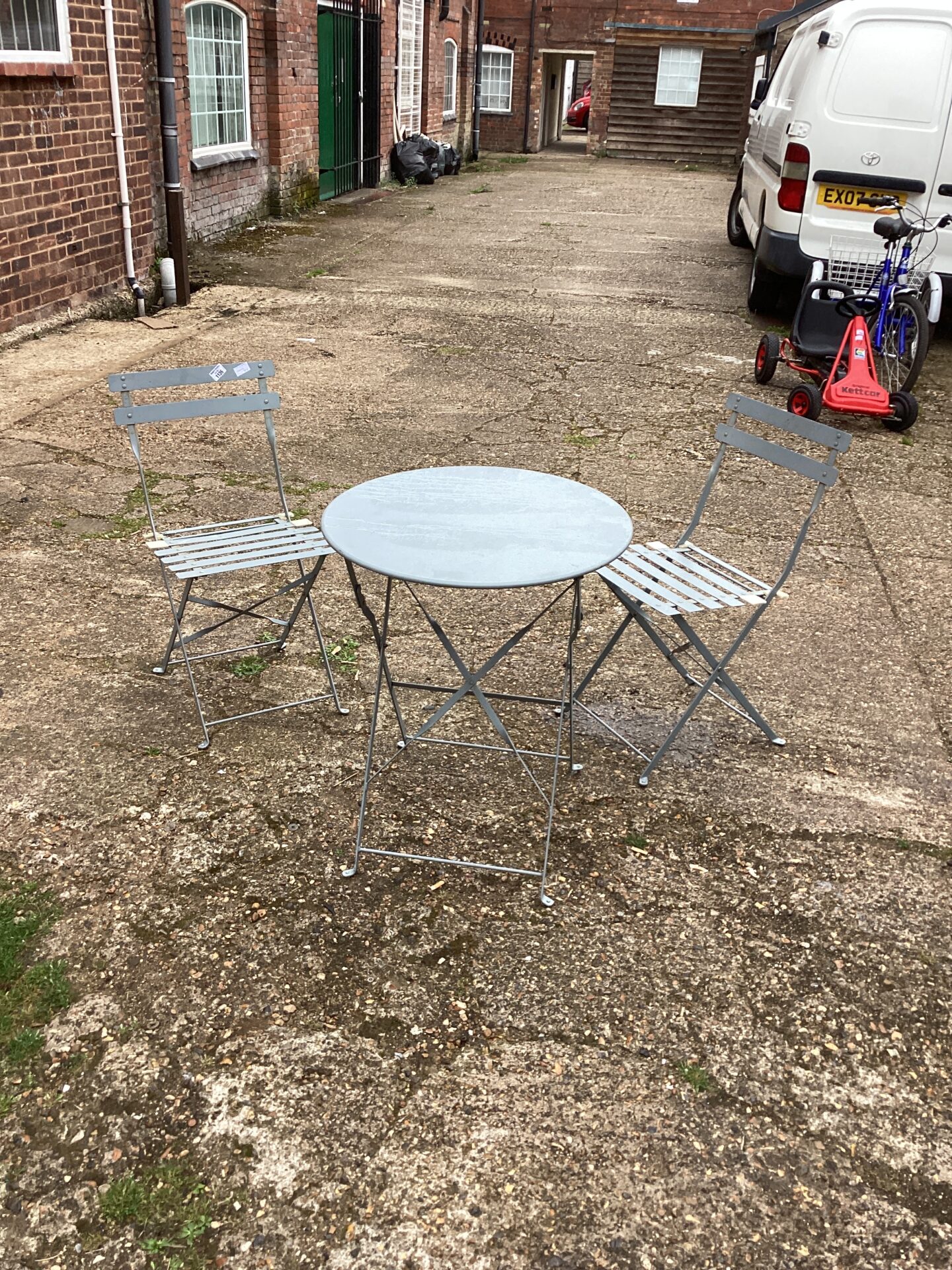 Two metal garden chairs and table