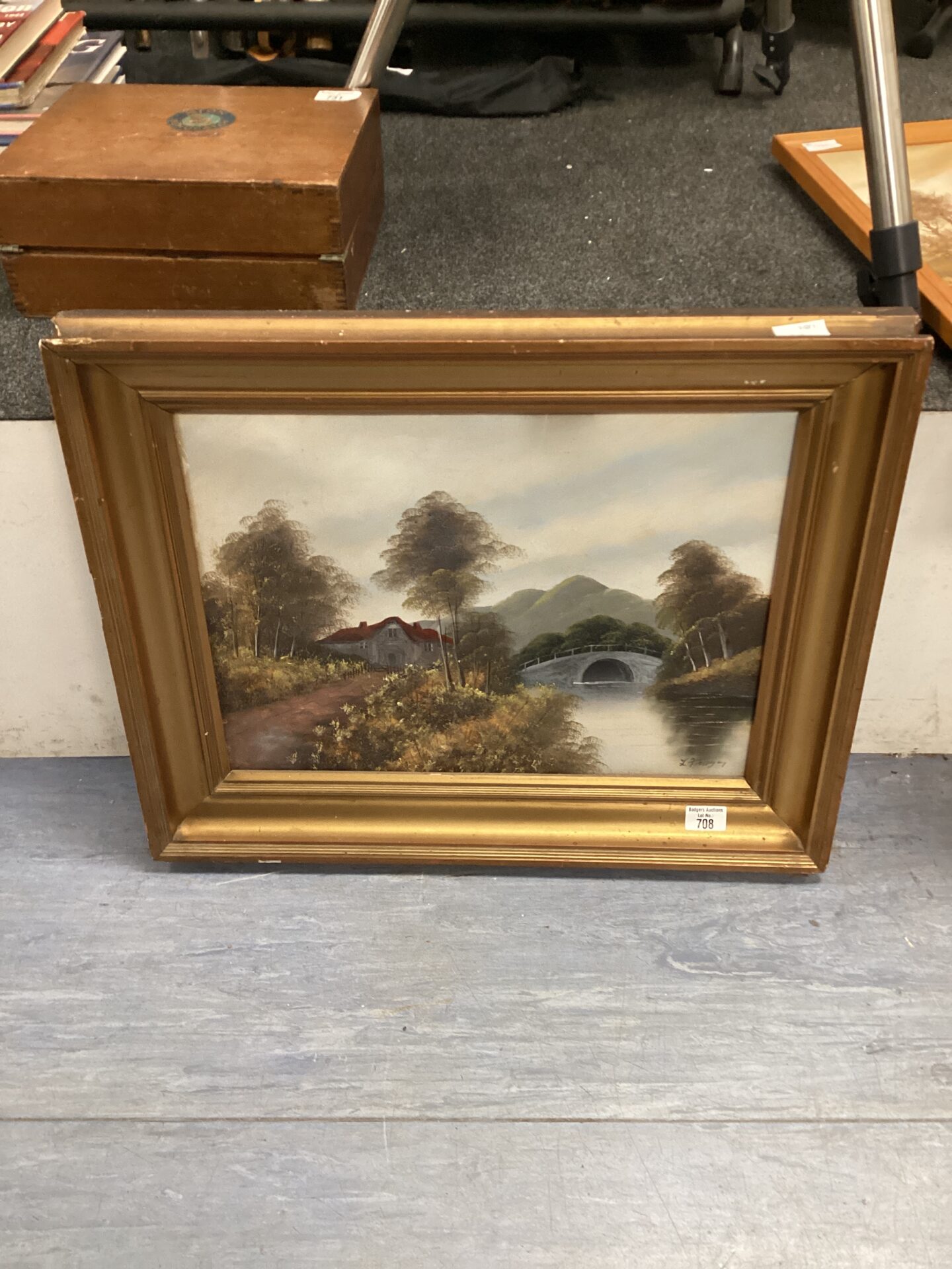 gilt framed oil on board of cottage by the river signed
