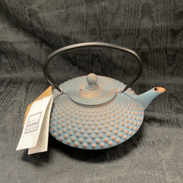 A charming blue and white teapot with a handle on the side.